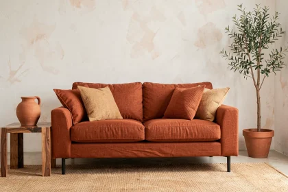 Salon moderne avec canapé en lin terracotta, vase en argile et tapis en jute sur parquet en noyer